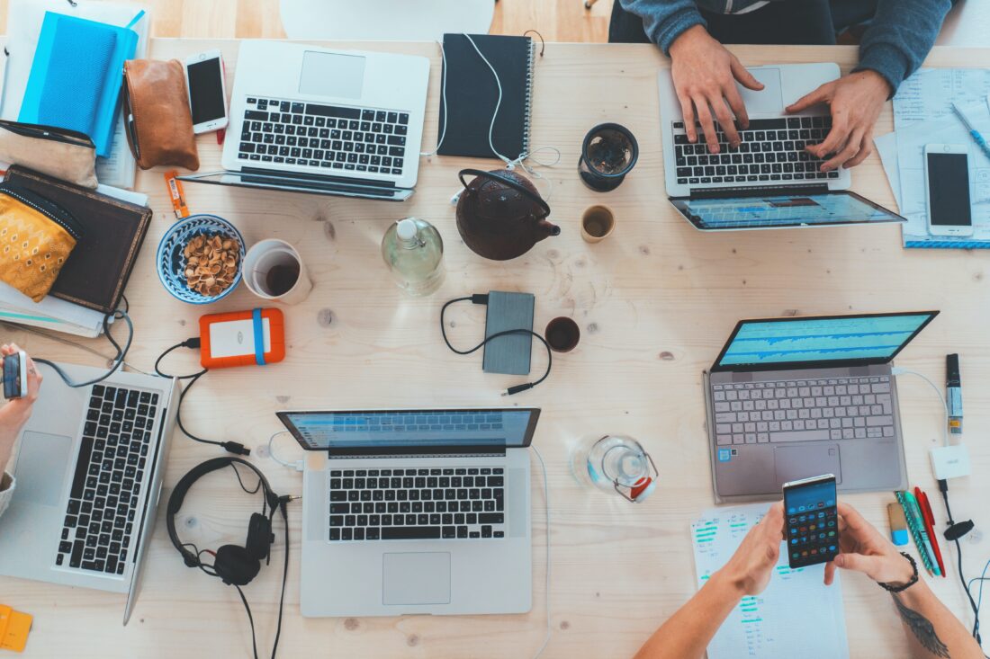 Collaborative team sitting at a table with computers out