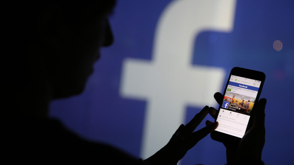 Suspicious figure browsing facebook